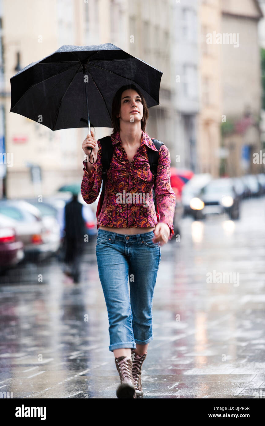Woman walking down the street in the rain Stock Photo - Alamy