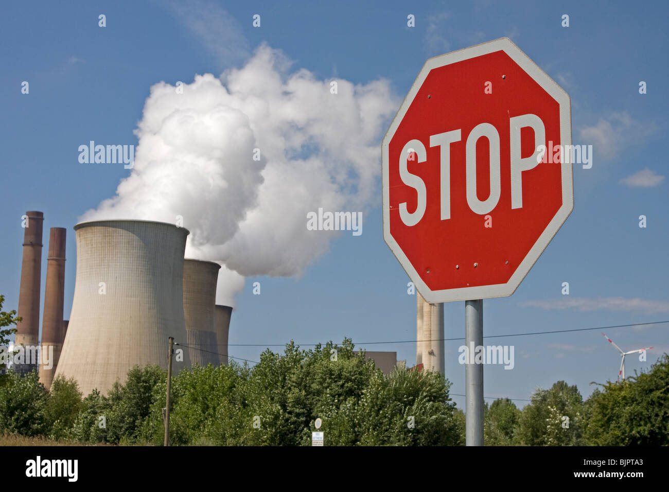 smoky cooling tower with a stop sign Stock Photo