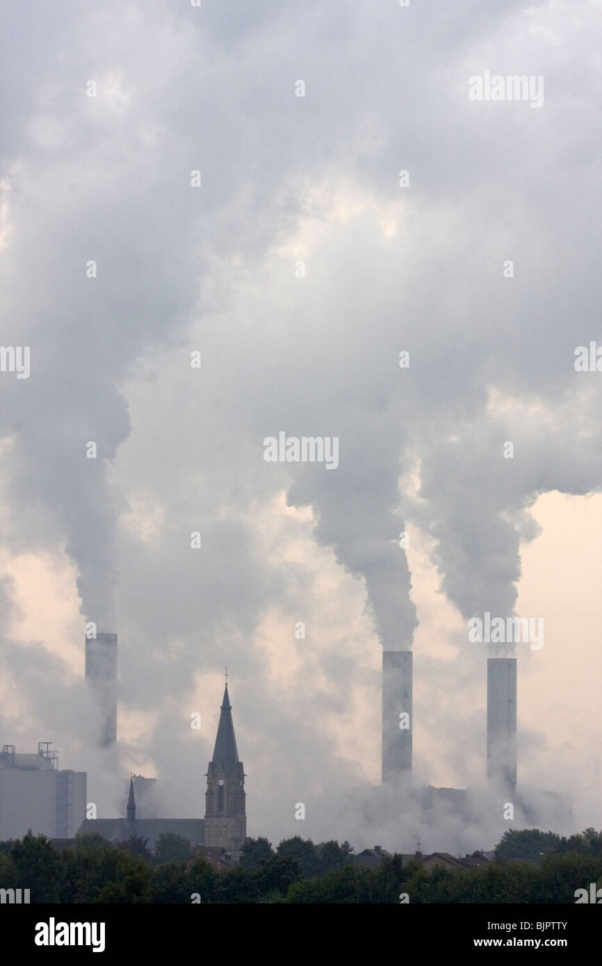 church with smoky power plant Stock Photo