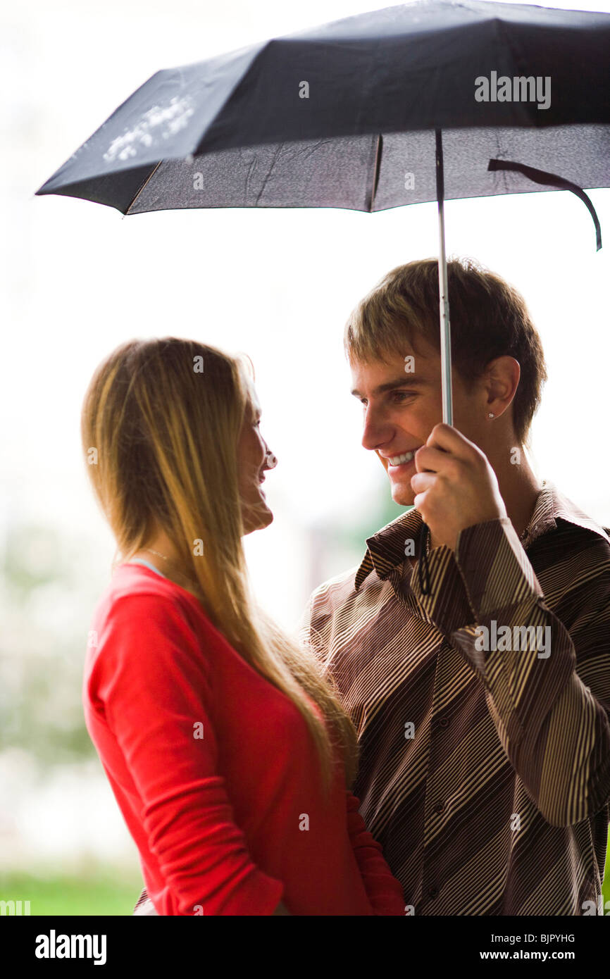 Couple with umbrella in the rain Stock Photo - Alamy