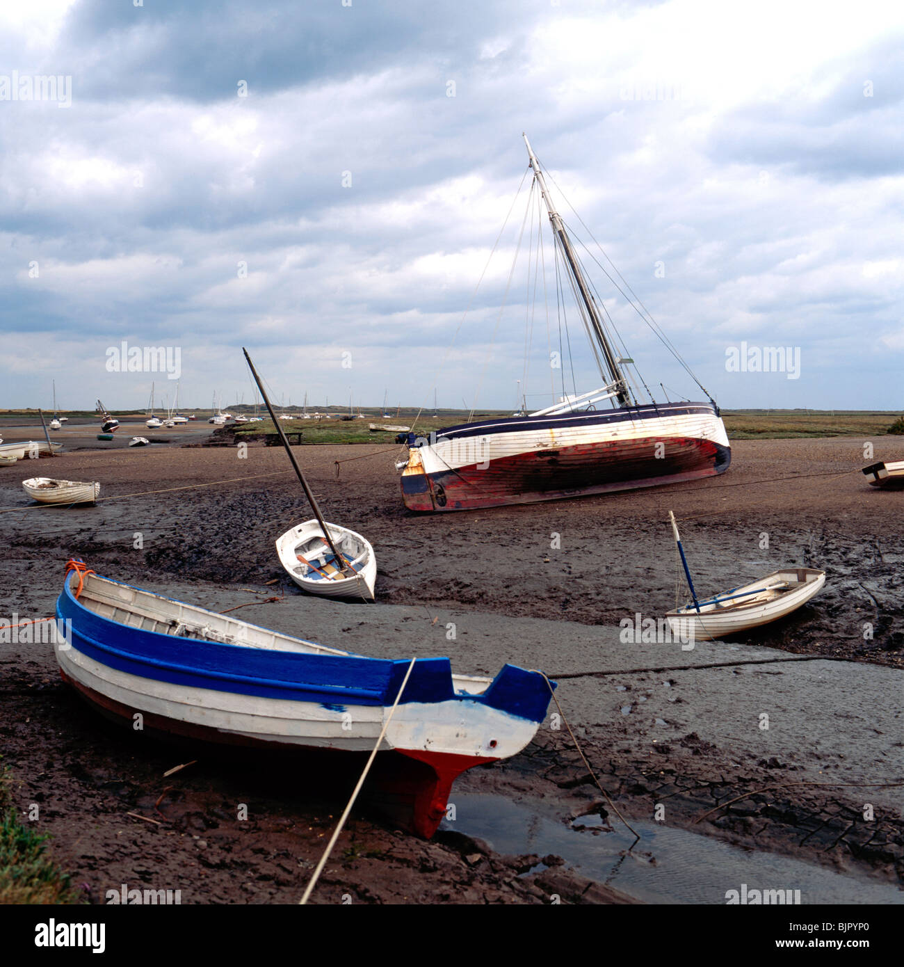 Boats mored on the bed of an estuary after the tide has gone out Stock Photo
