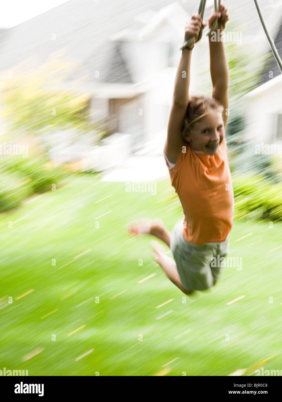 Girl swinging on rope Stock Photo