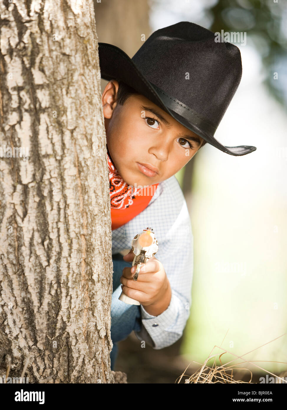 Boy in cowboy costume with toy gun Stock Photo