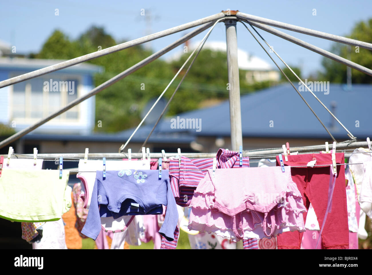 Hills hoist washing line with laundry drying in Australian backyard garden. Stock Photo