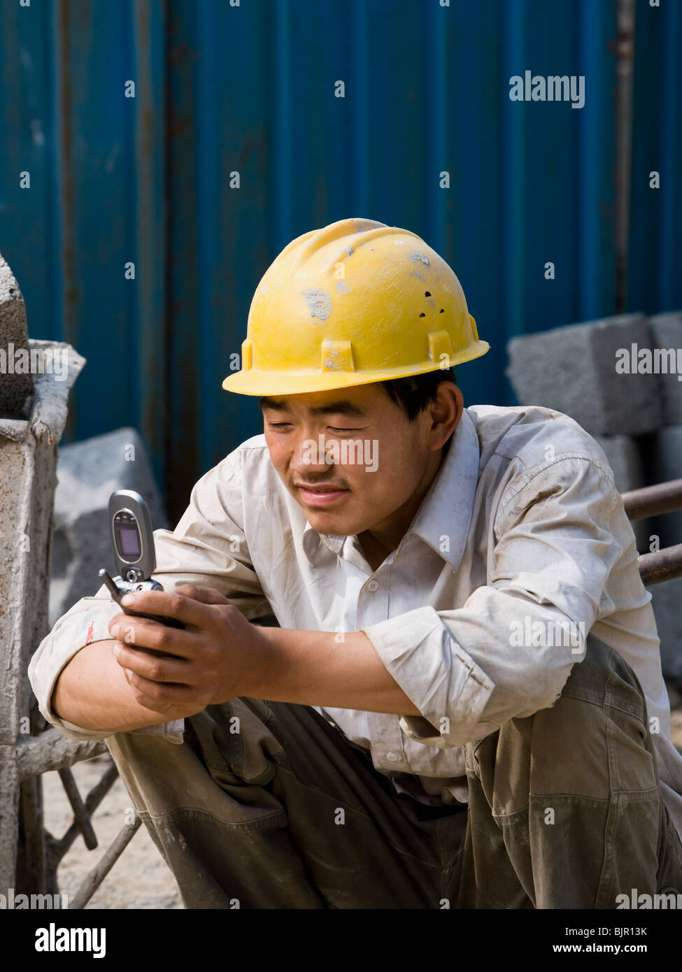 Construction worker looking at his cell phone Stock Photo Alamy