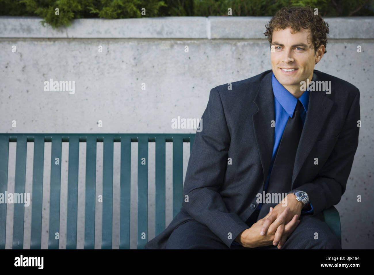 Businessman sitting on a bench Stock Photo - Alamy