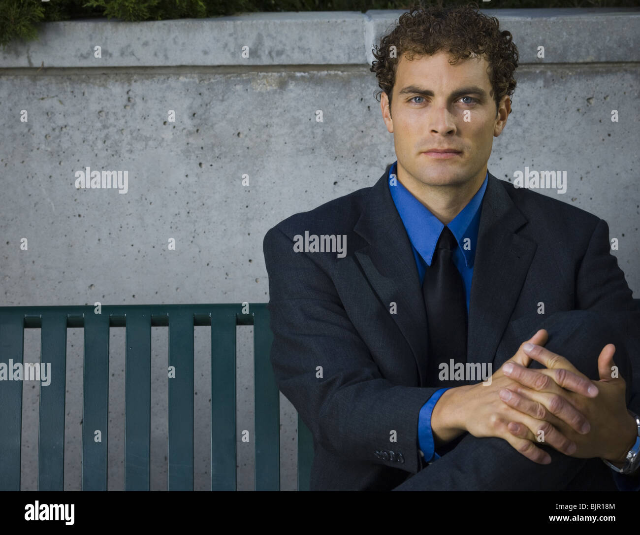 Businessman sitting on a bench Stock Photo - Alamy