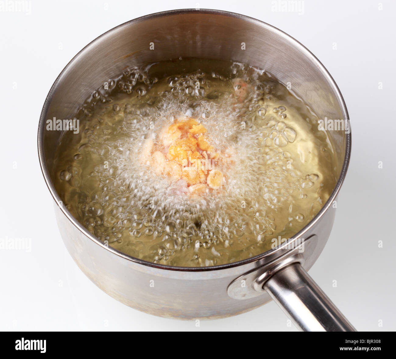 Chicken drumstick coated in corn flakes being deep fried Stock Photo