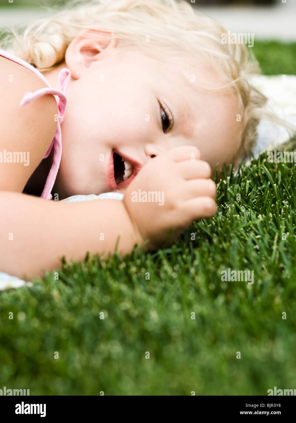 little girl lying on a blanket on the grass Stock Photo Alamy