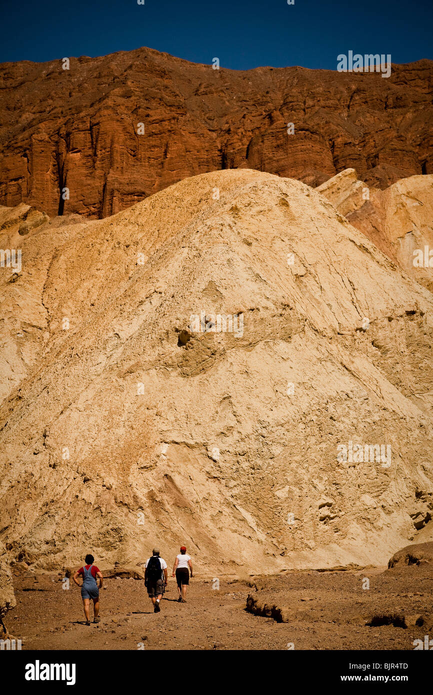 Hikers at the badlands at Golden Canyon in Death Valley National Park ...