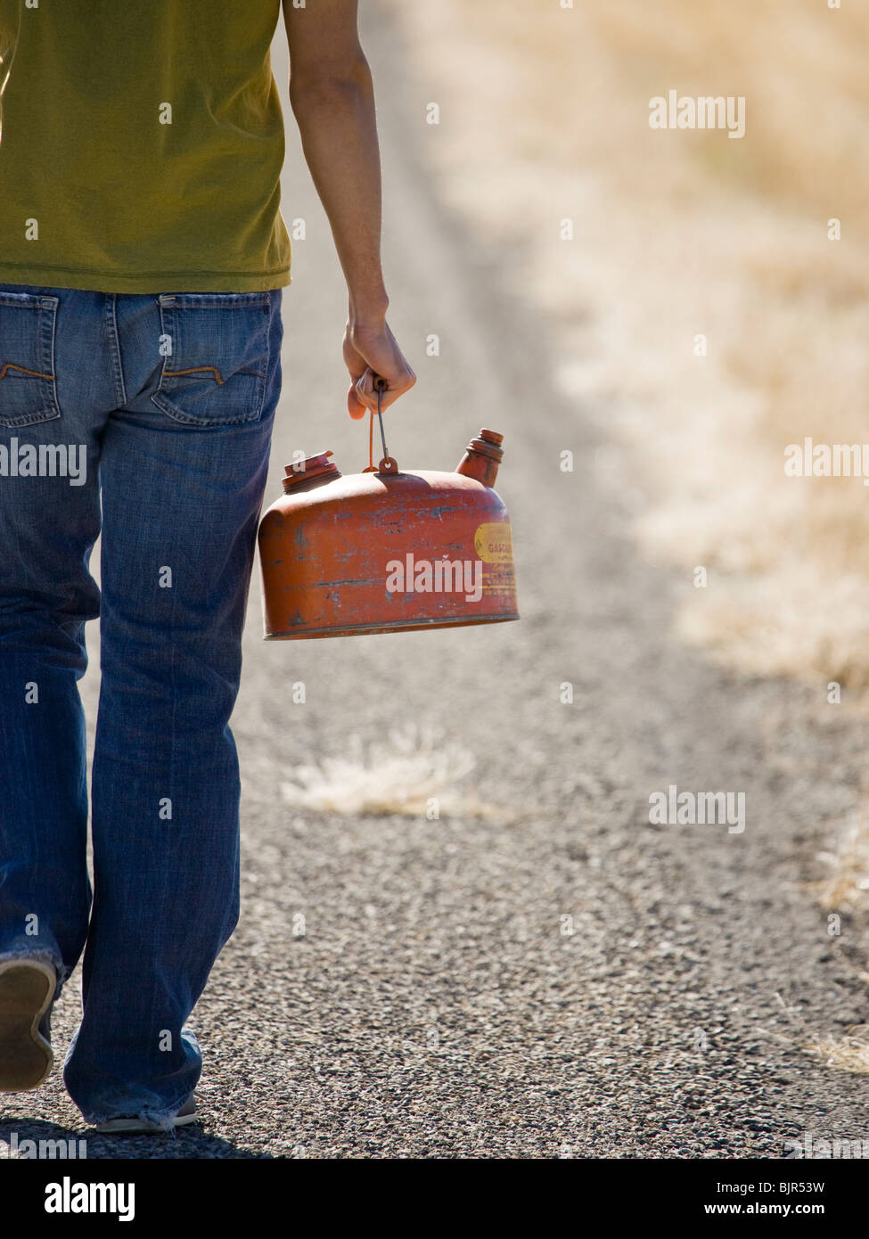 man walking with a gas can Stock Photo
