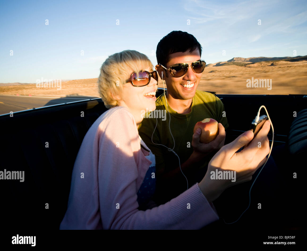 man and woman next to a red convertible Stock Photo