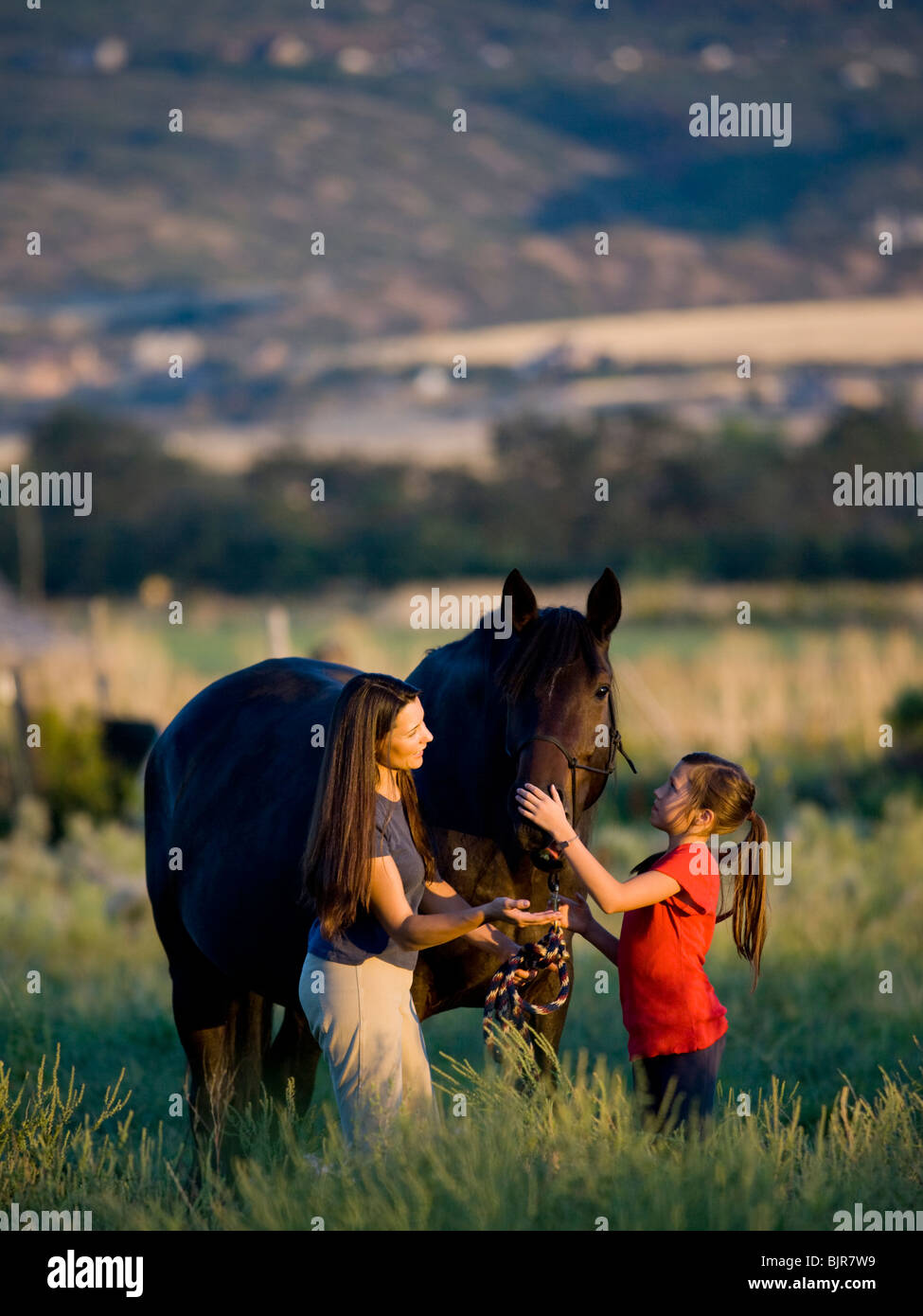 woman, girl, and a horse Stock Photo