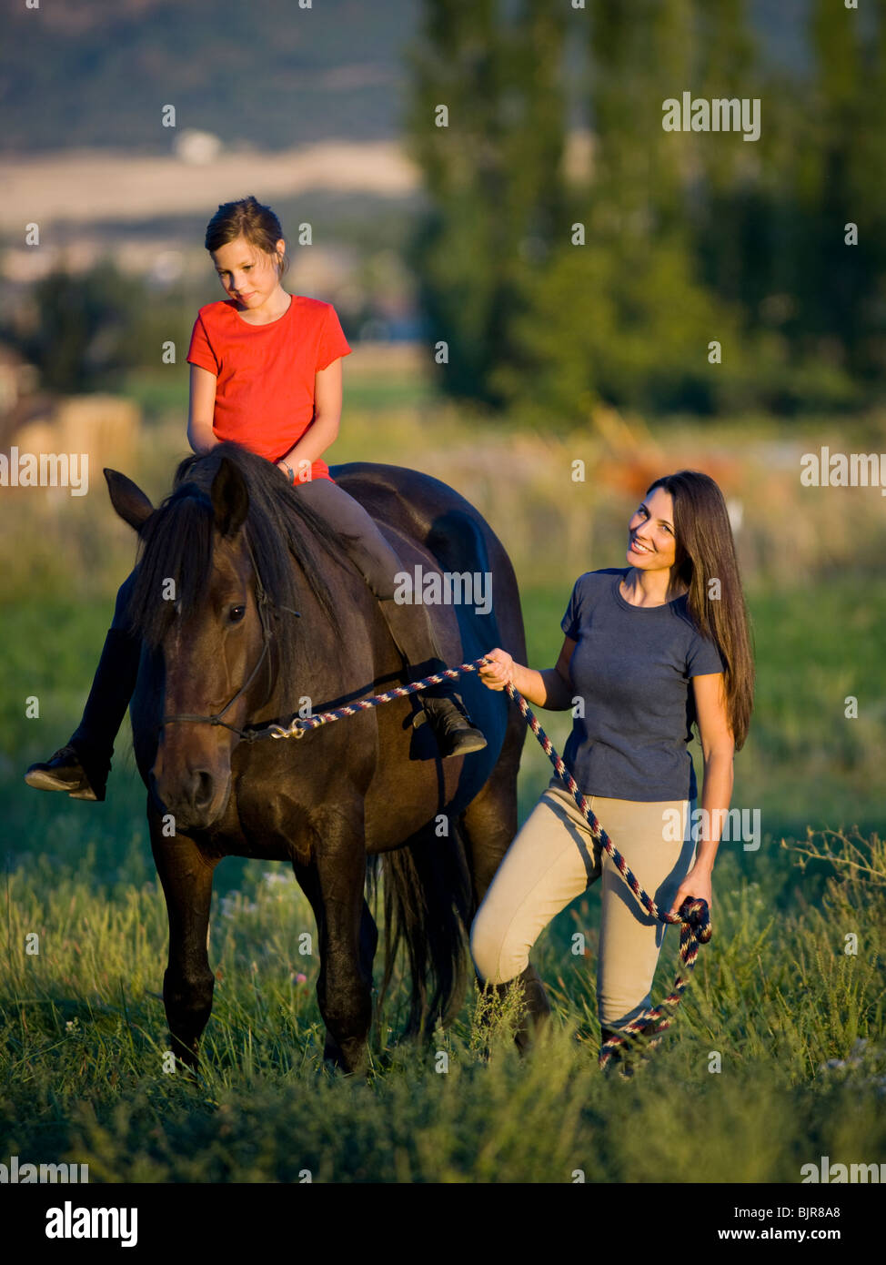 mother and daughter with a horse Stock Photo