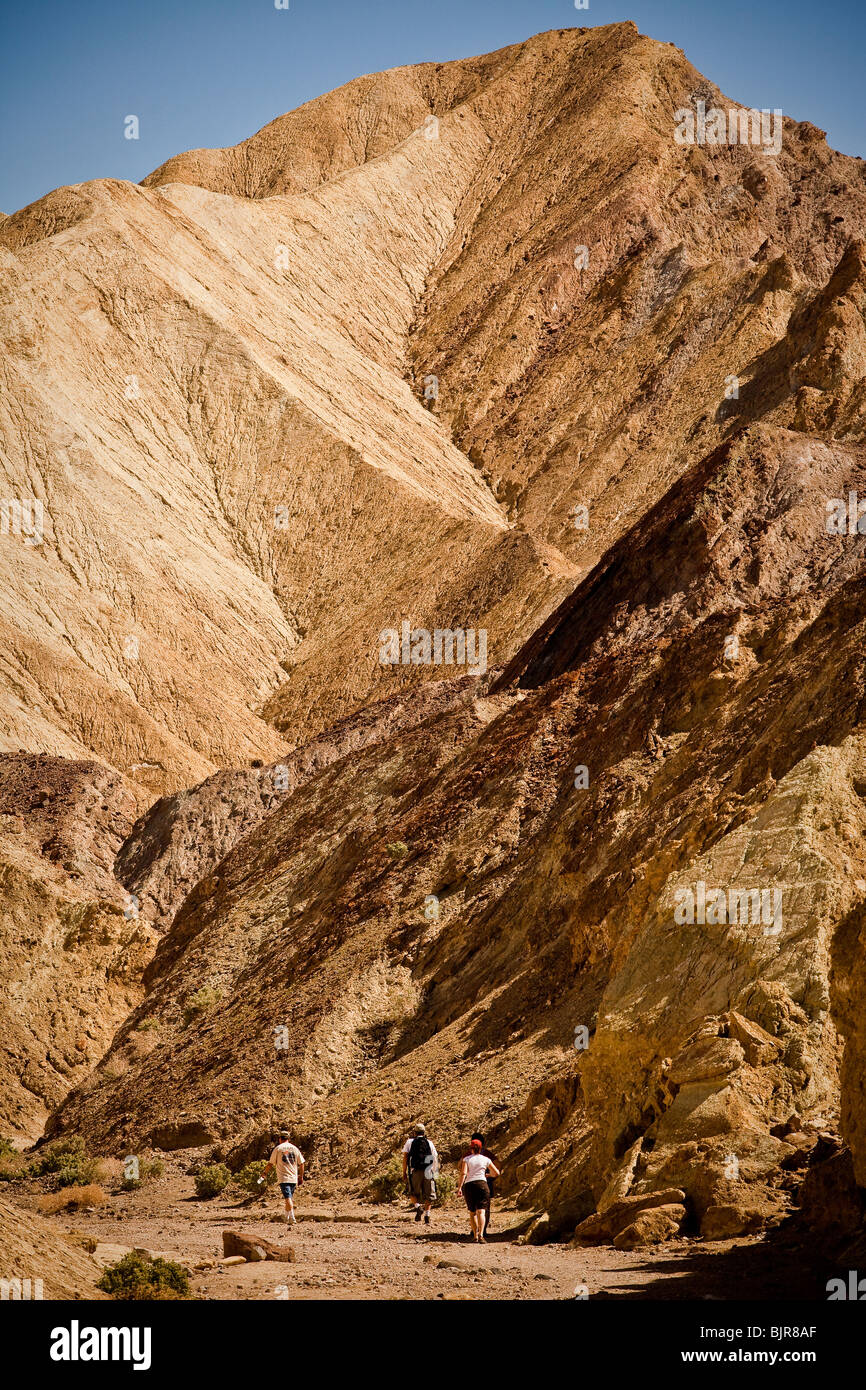 Hikers at the badlands at Golden Canyon in Death Valley National Park ...