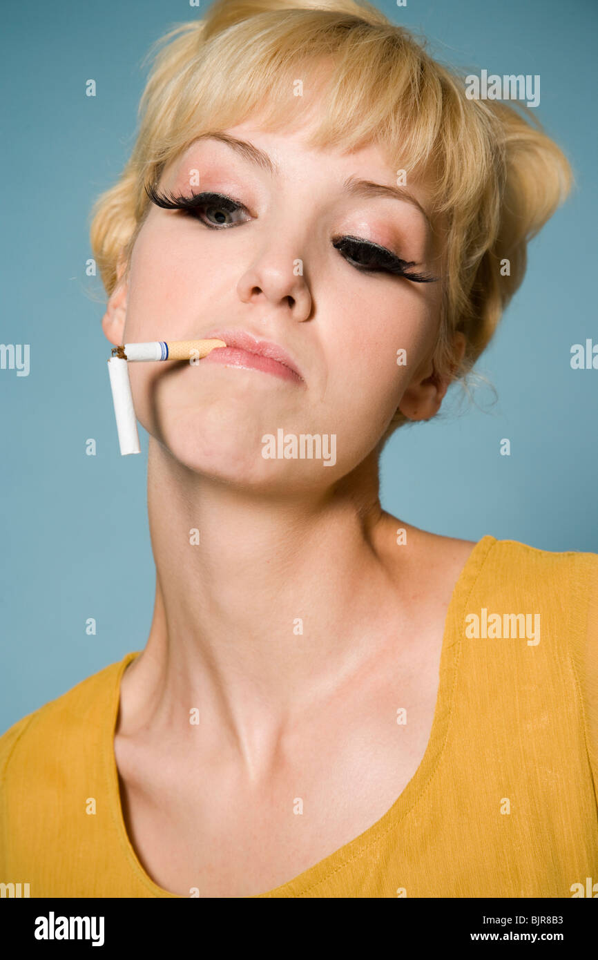 woman with a broken cigarette in her mouth Stock Photo