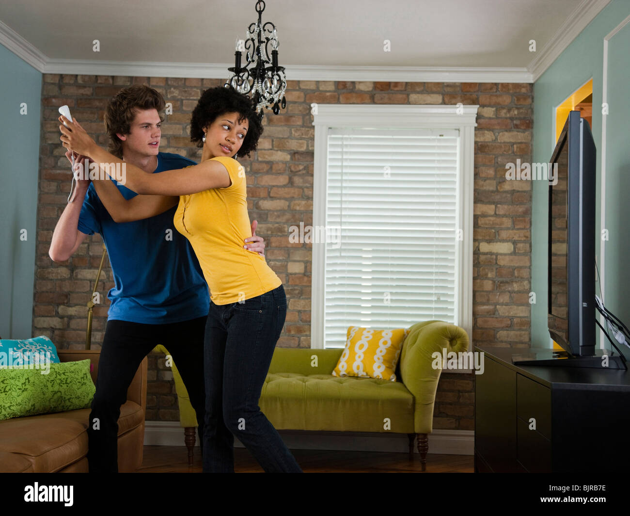 USA, Utah, Provo, young couple holding remote control in living room Stock Photo