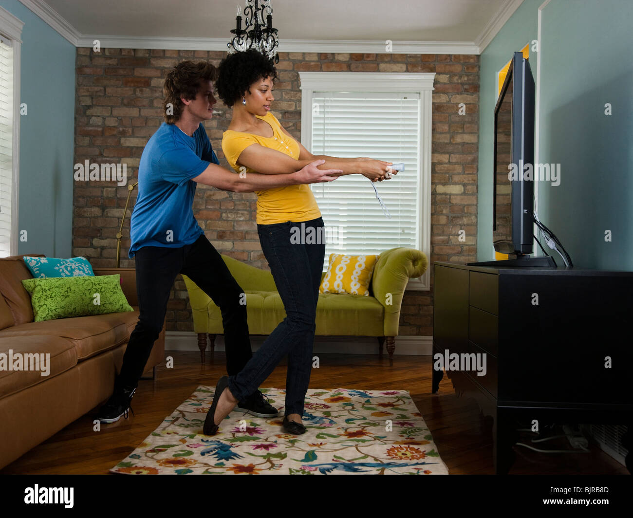USA, Utah, Provo, young couple using remote control in living room Stock Photo