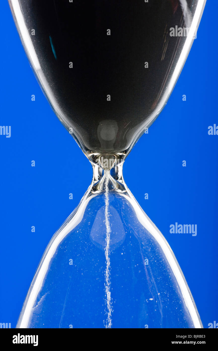 Close-up of hourglass on blue background Stock Photo