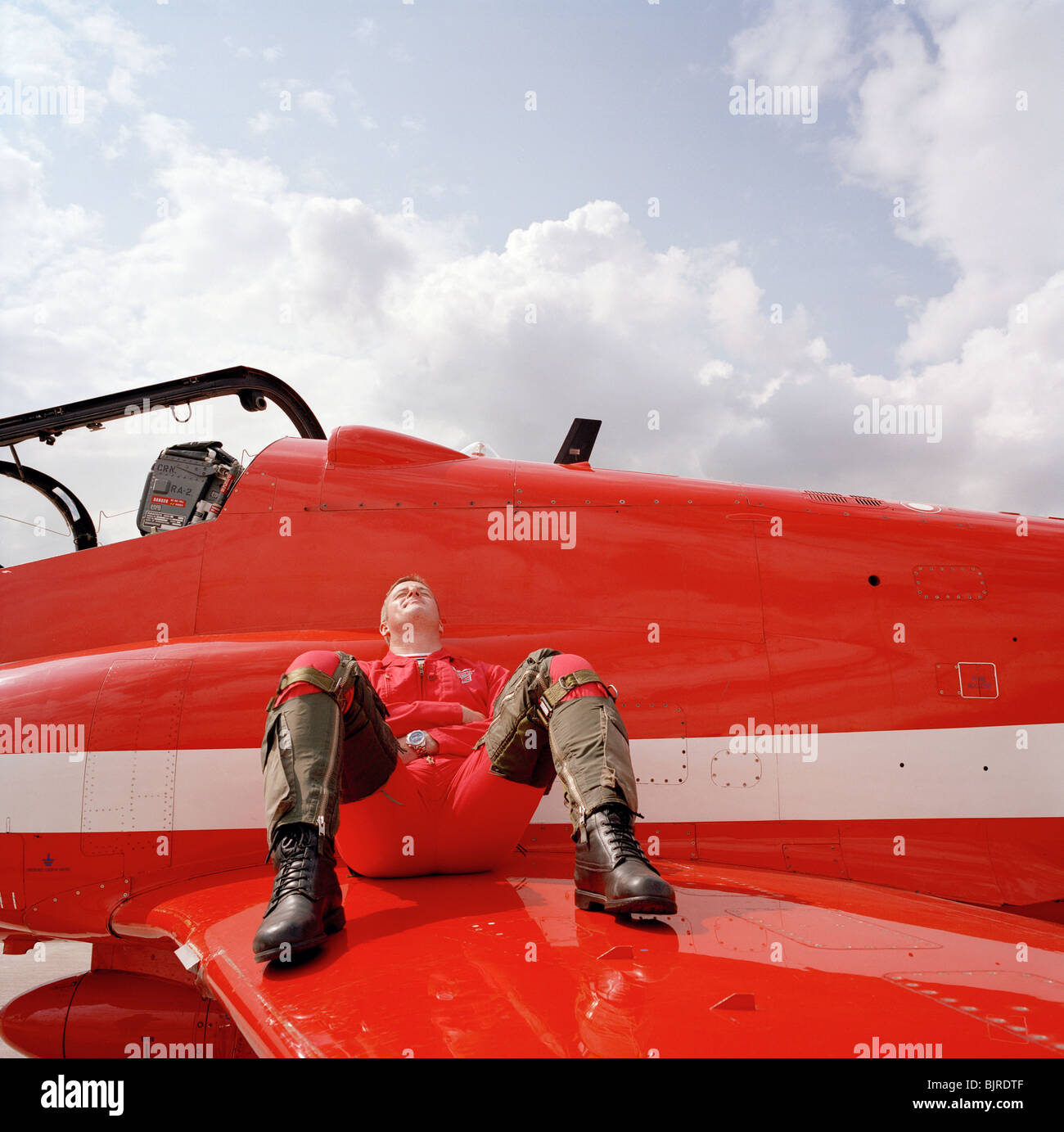 Squadron Leader David Thomas of the RAF aerobatic display team Red Arrows relaxes on the wing on his Hawk jet before a show. Stock Photo