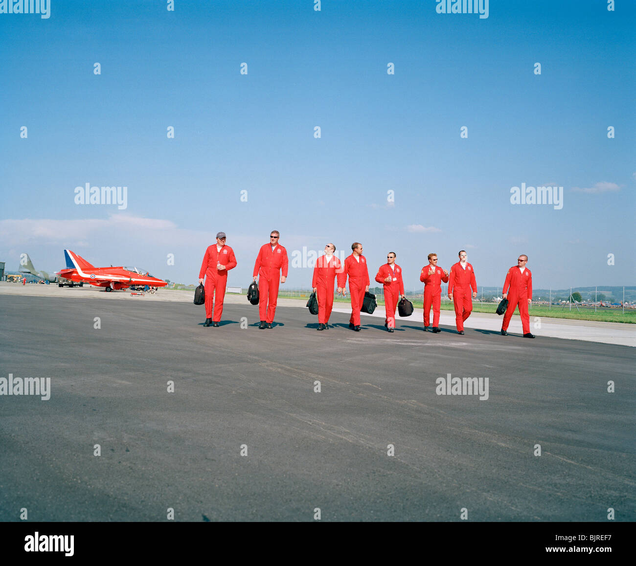RAF aerobatic Red Arrows pilots walk away in line from their Hawk jets