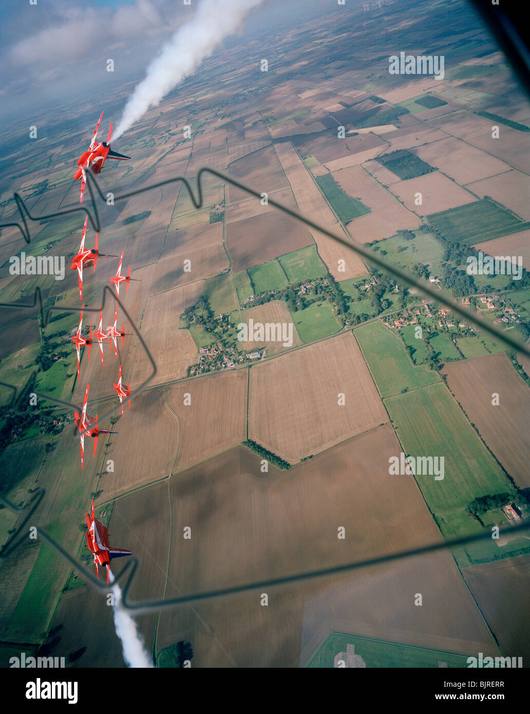 The Red Arrows aerobatic team practice their displays above the Lincolnshire farm land. See below. Stock Photo