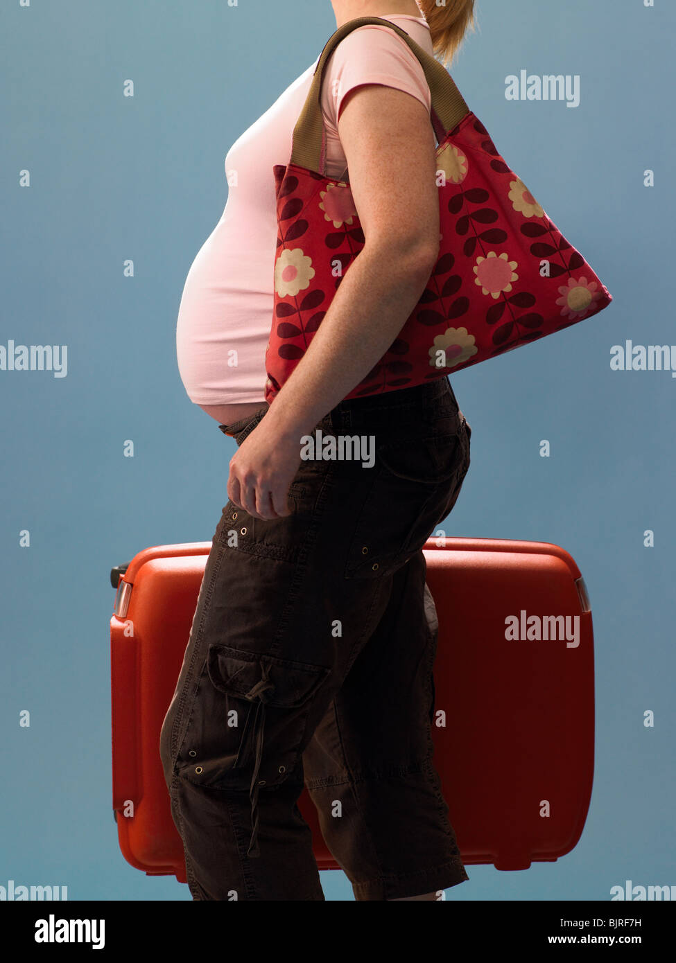 Pregnant woman carrying suitcase Stock Photo Alamy