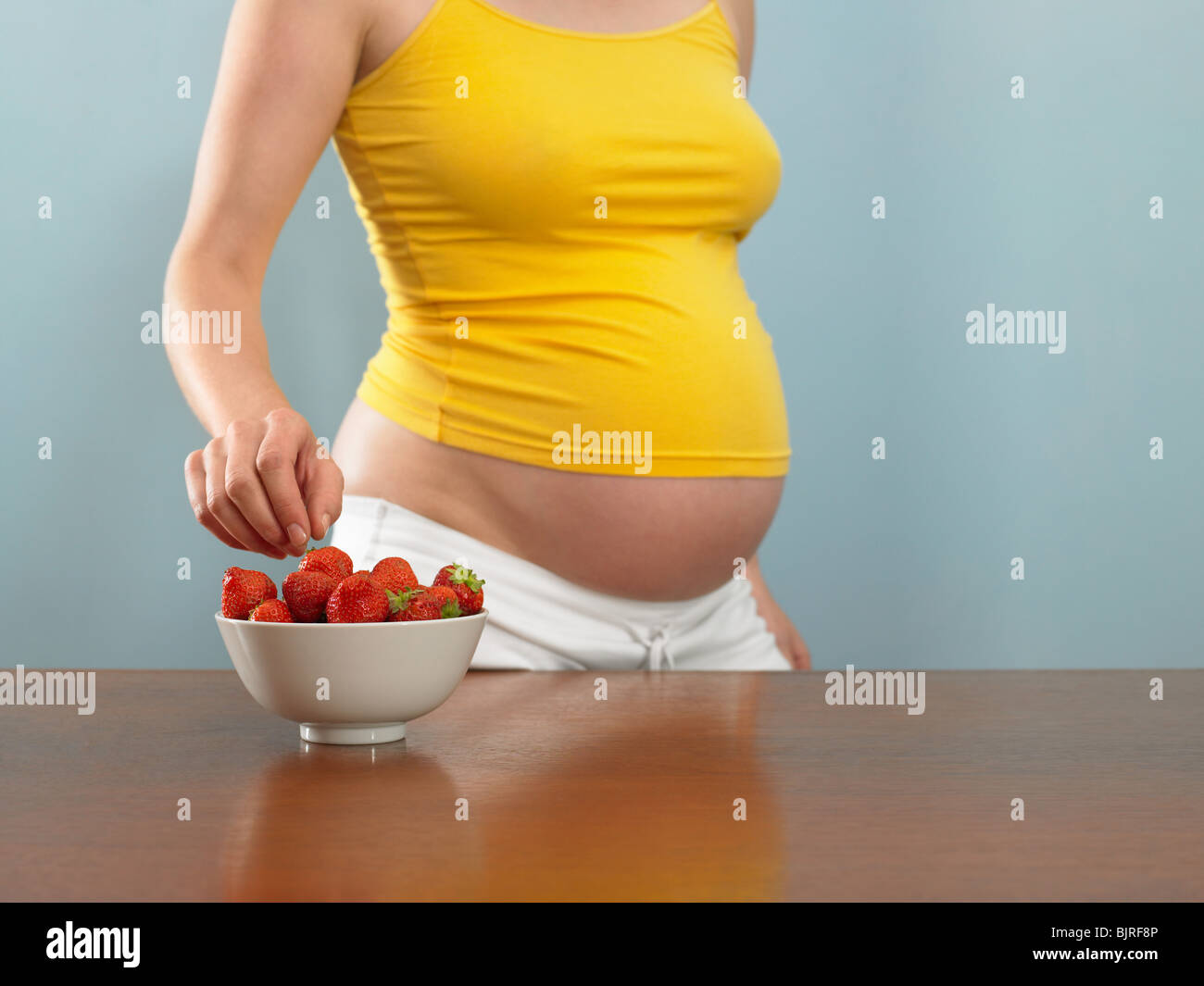 Pregnant woman choosing a strawberry Stock Photo Alamy