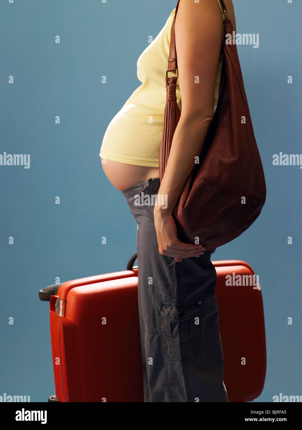 Pregnant woman carrying suitcase Stock Photo Alamy