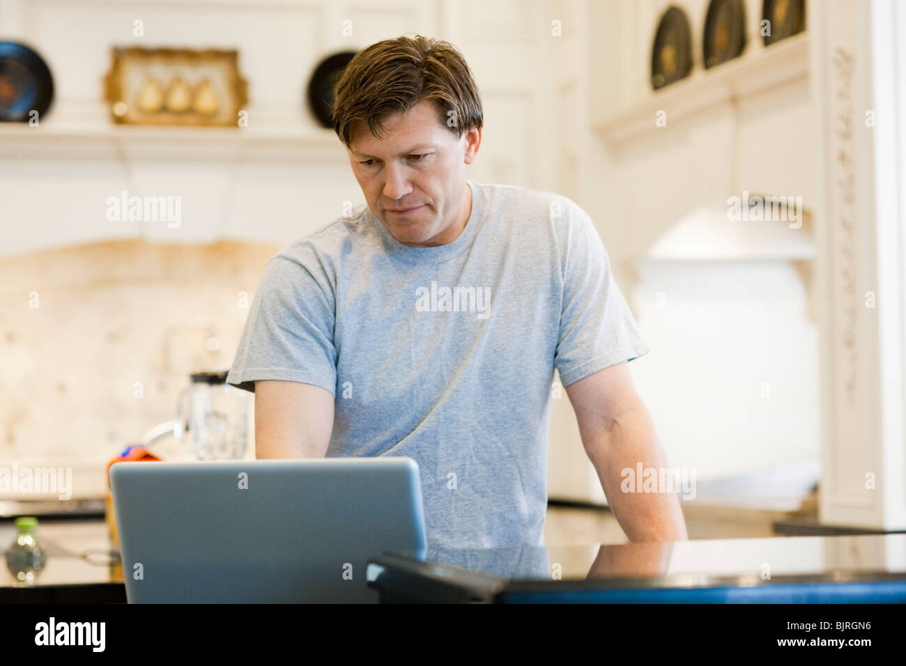 Mature man at home using laptop hi-res stock photography and images - Alamy
