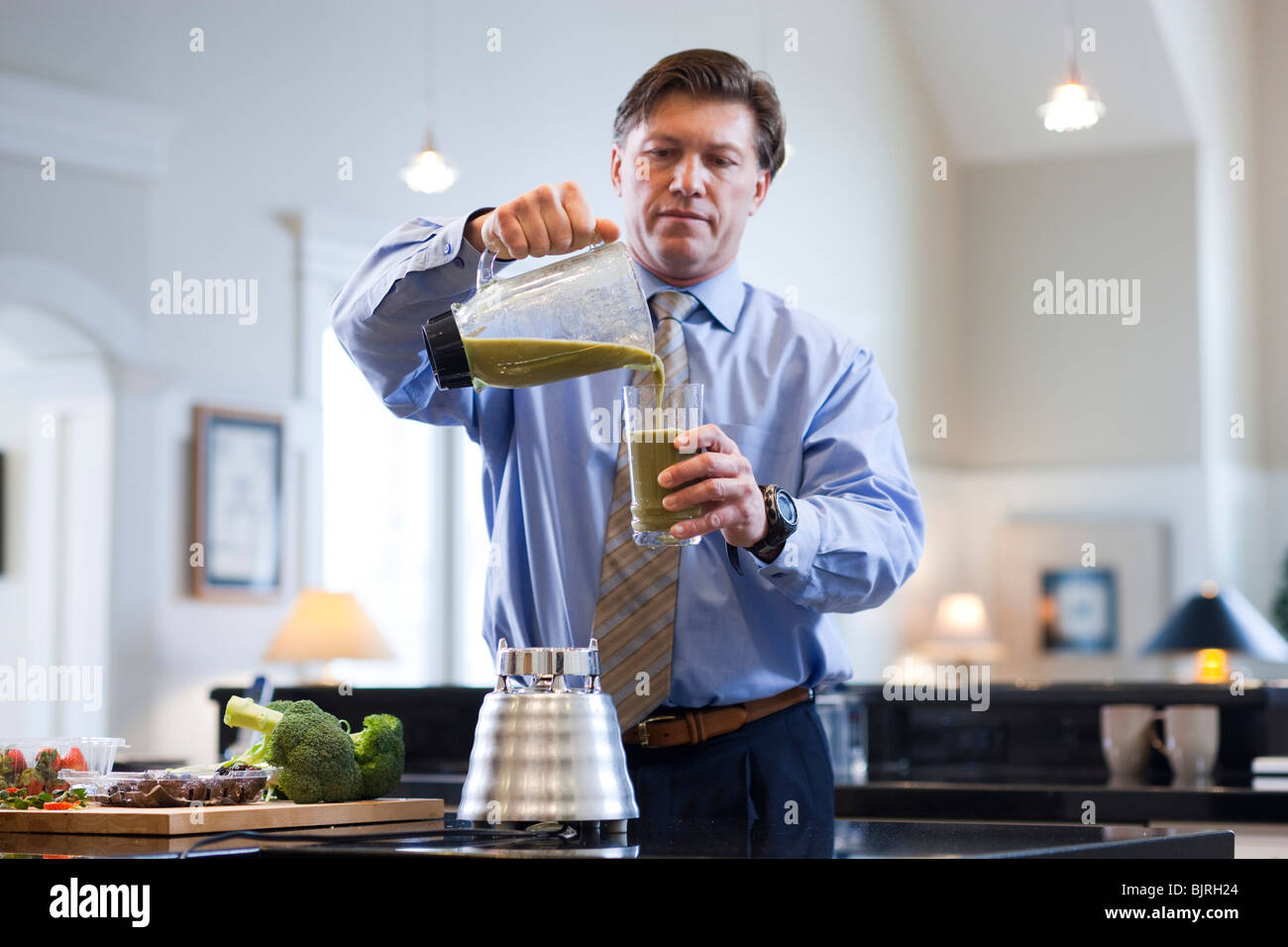 USA, Utah, Alpine, mature man pouring vegetable drink from pitcher to glass Stock Photo