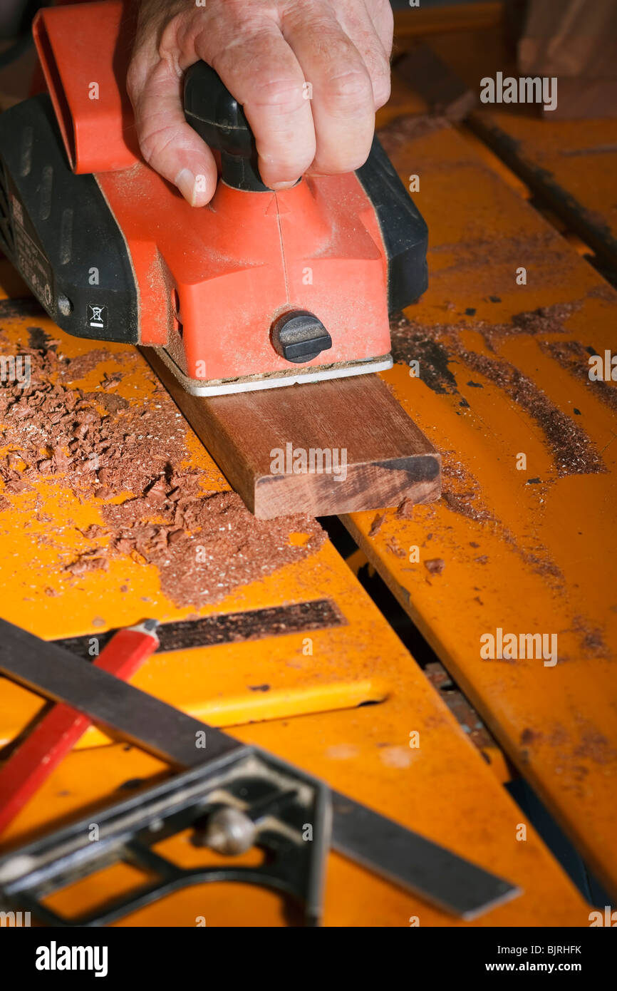 An electric plane being used on a section of timber. Stock Photo