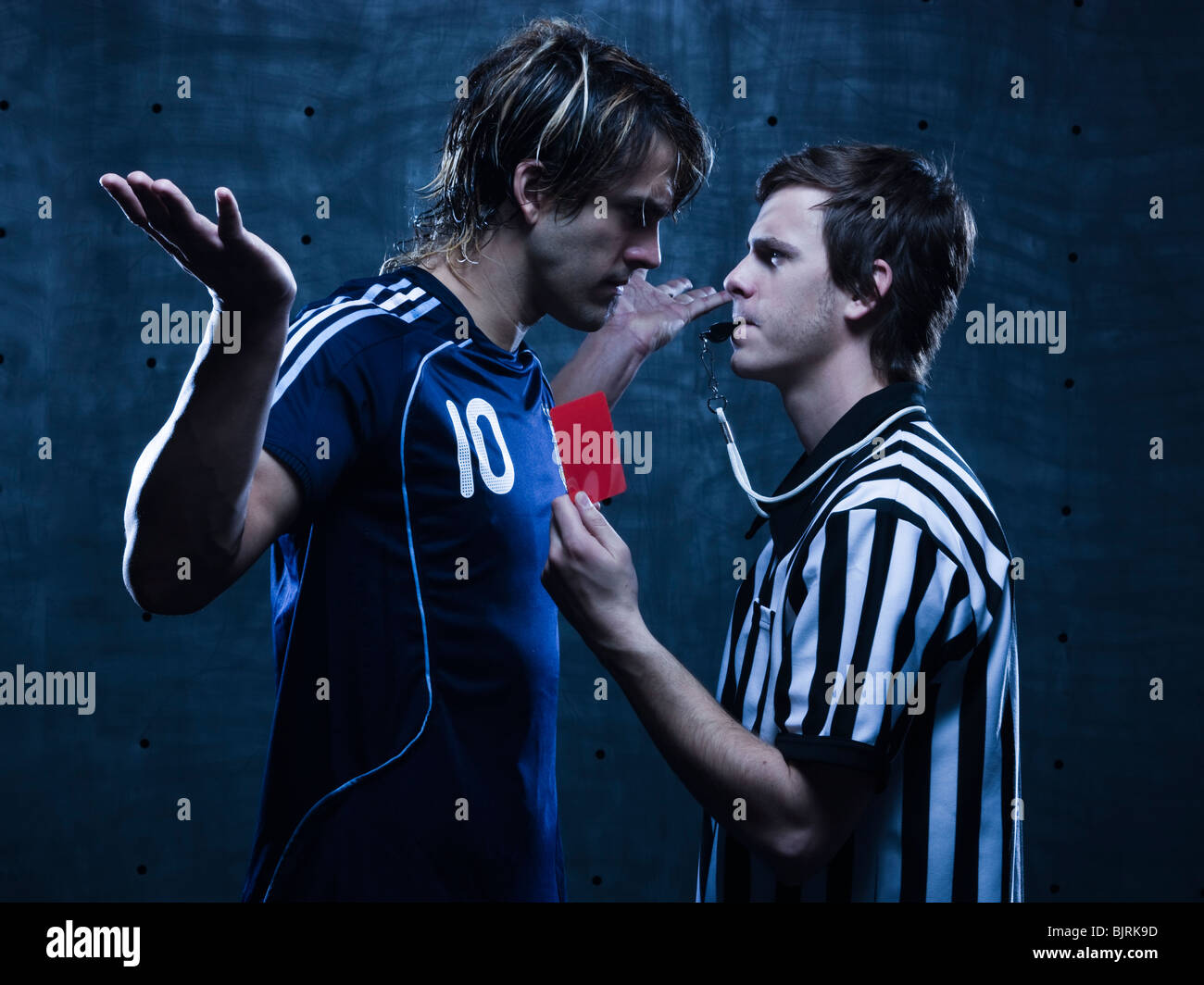 Studio shot of referee showing red card to soccer player Stock Photo ...