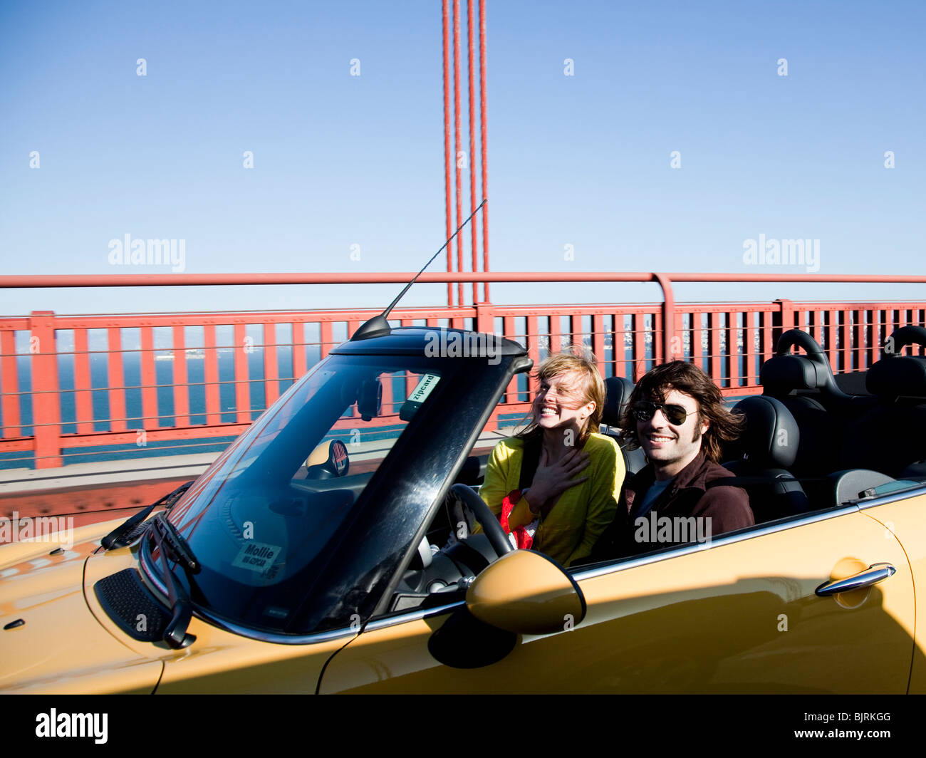 USA, California, San Francisco, young couple passing Golden Gate Bridge in convertible car Stock Photo