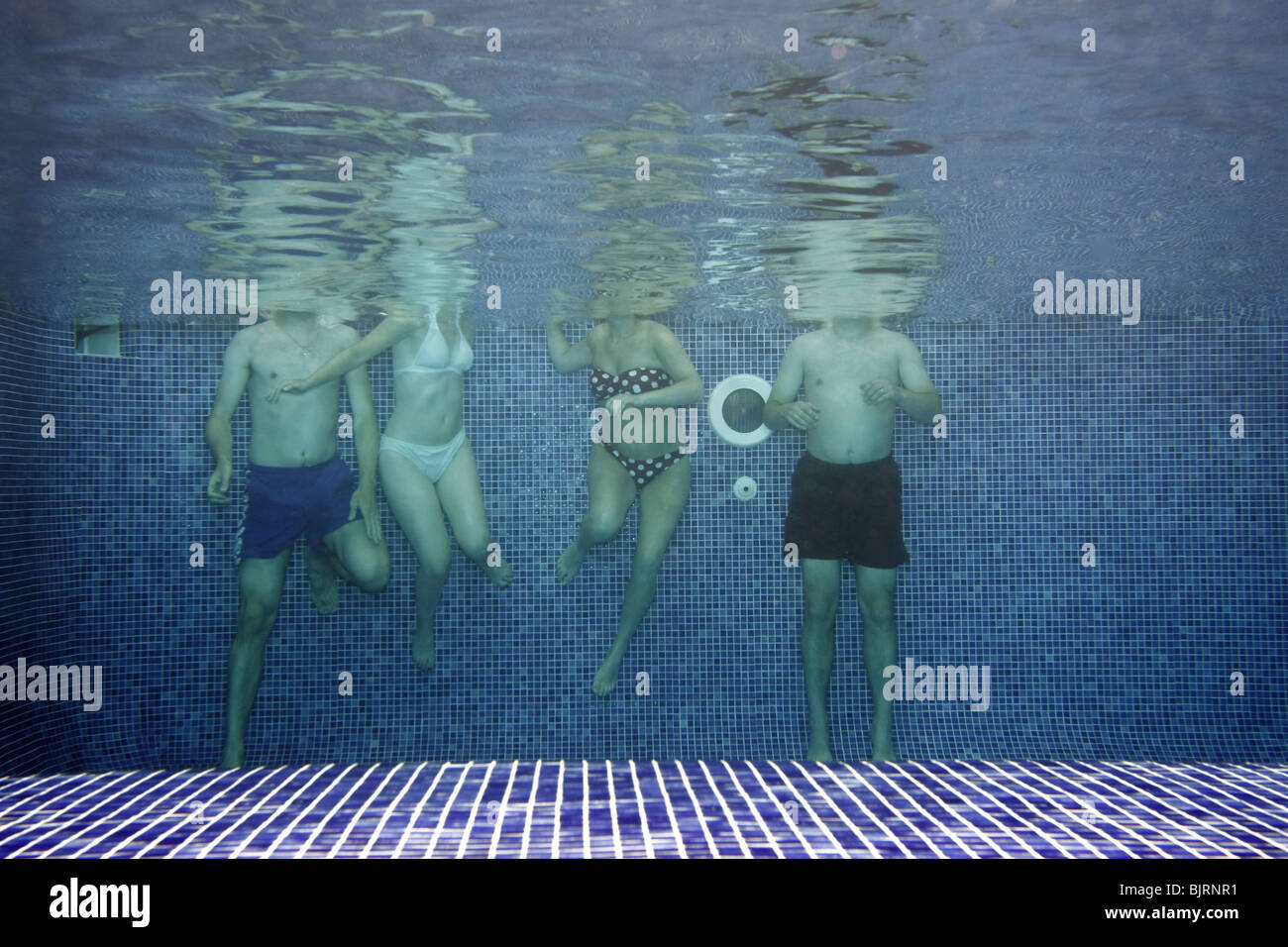 Underwater picture of people having fun in the swimming-pool Stock Photo