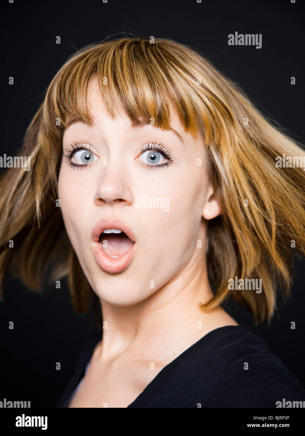 Studio portrait of shocked young woman Stock Photo
