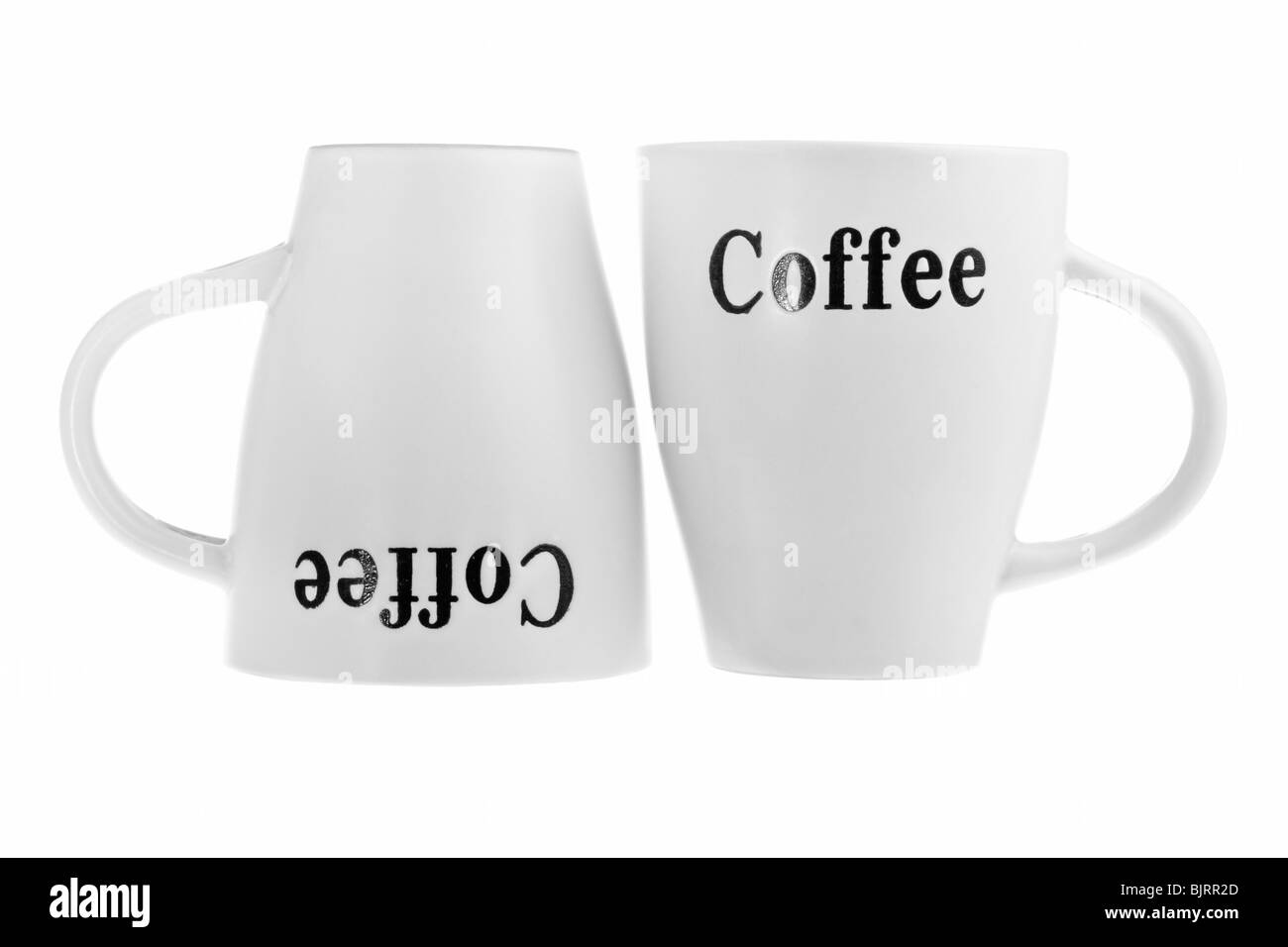 Two white coffee cups one upside-down isolated on white Stock Photo - Alamy