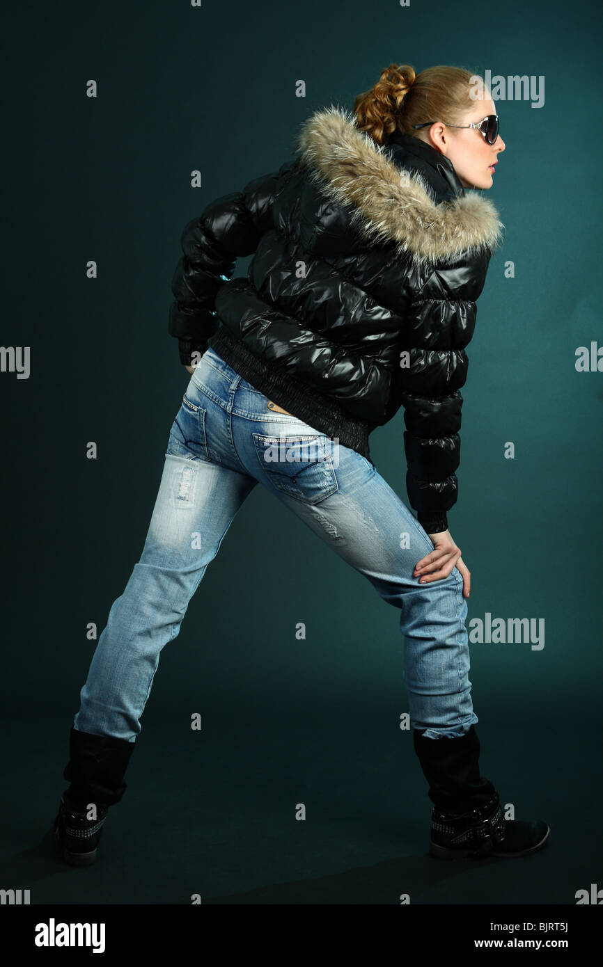 Girl in blue jeans and black jacket side view Stock Photo Alamy