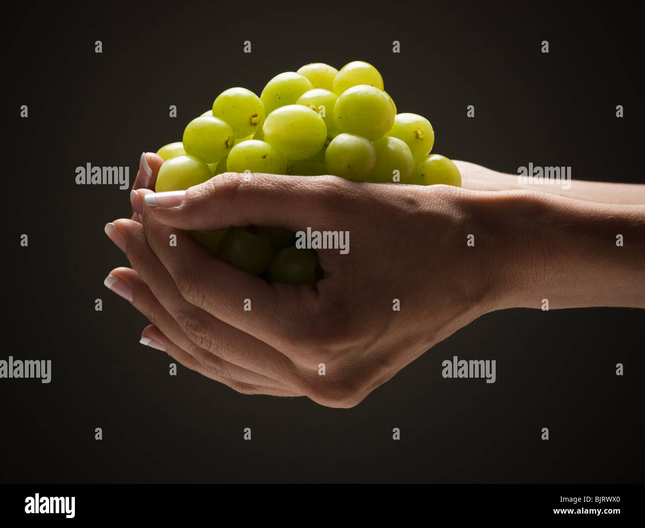 Hand holding grapes Stock Photo