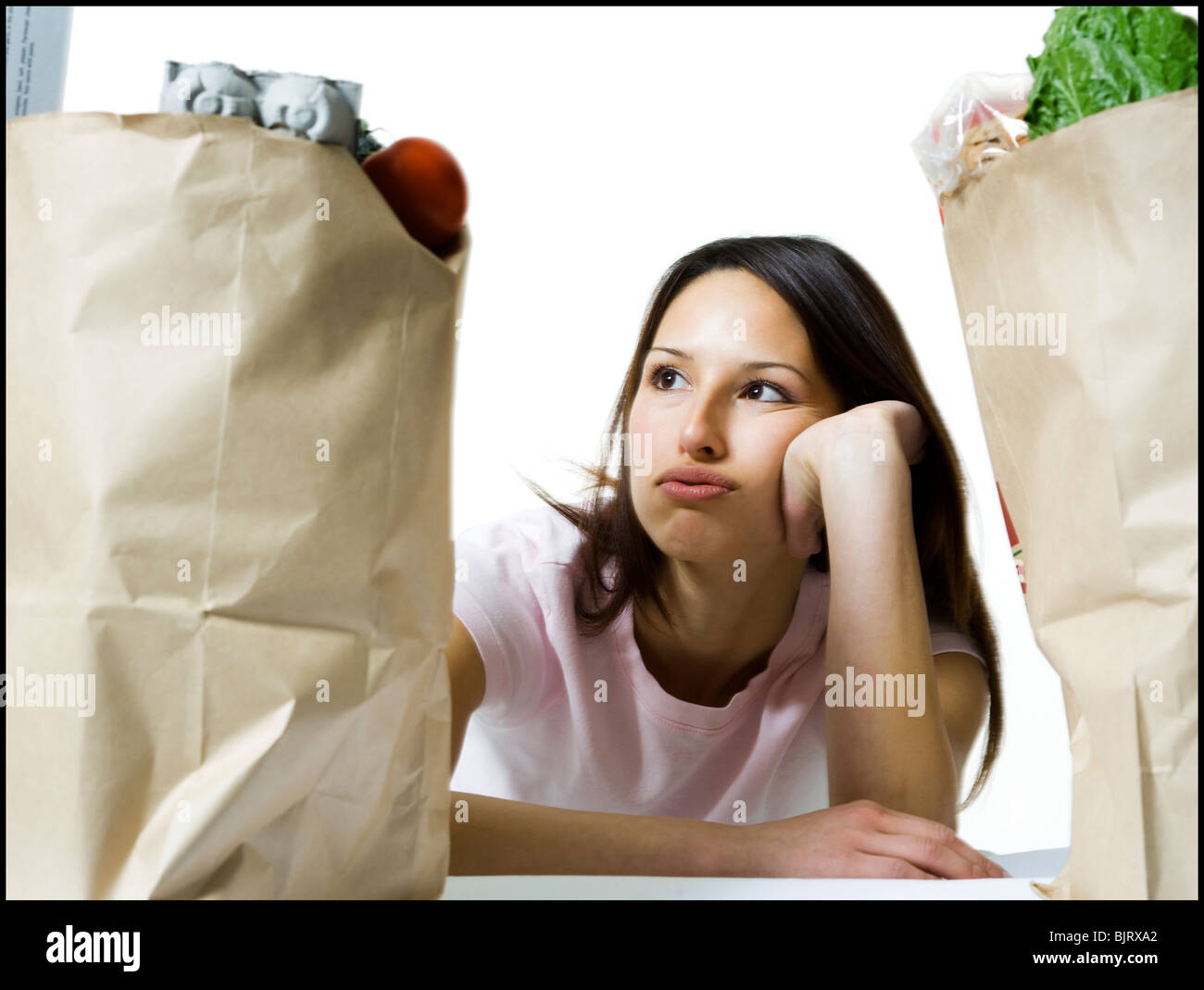 Woman in between two bags of groceries Stock Photo