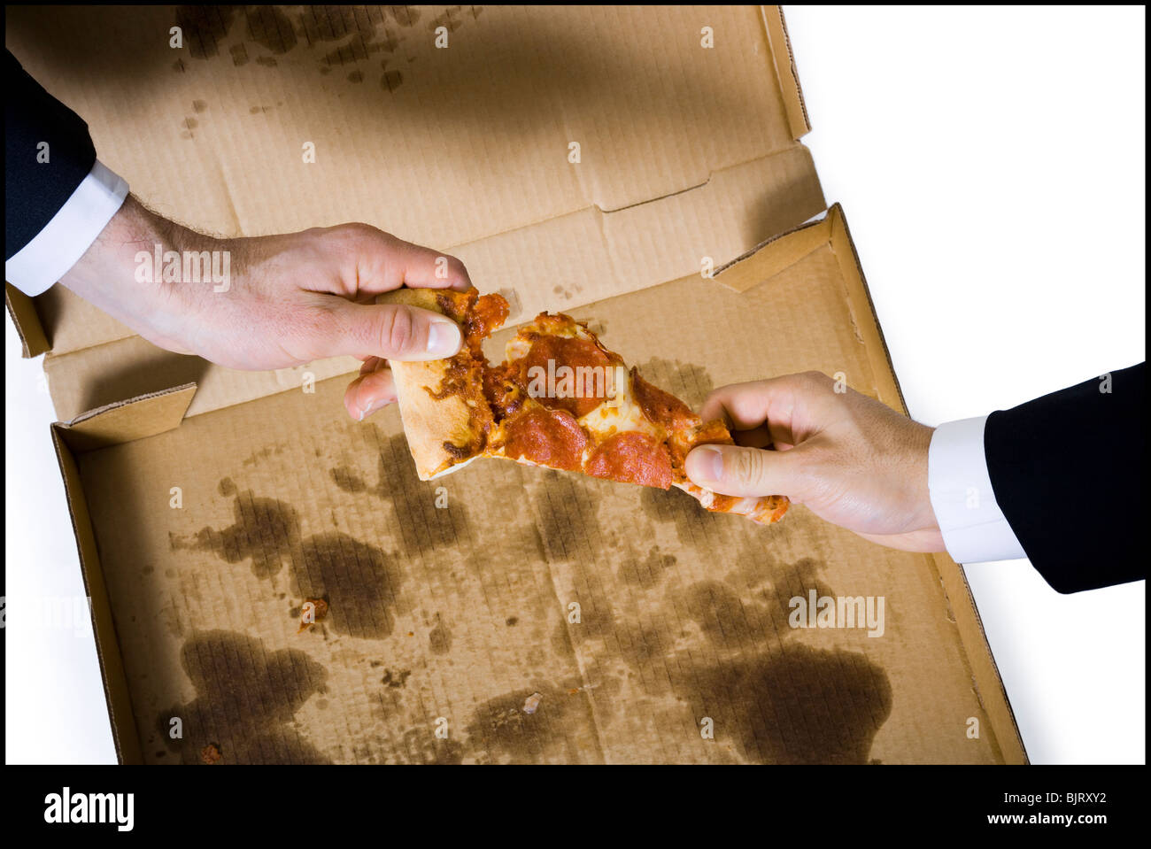 business men fighting over last slice of pizza Stock Photo