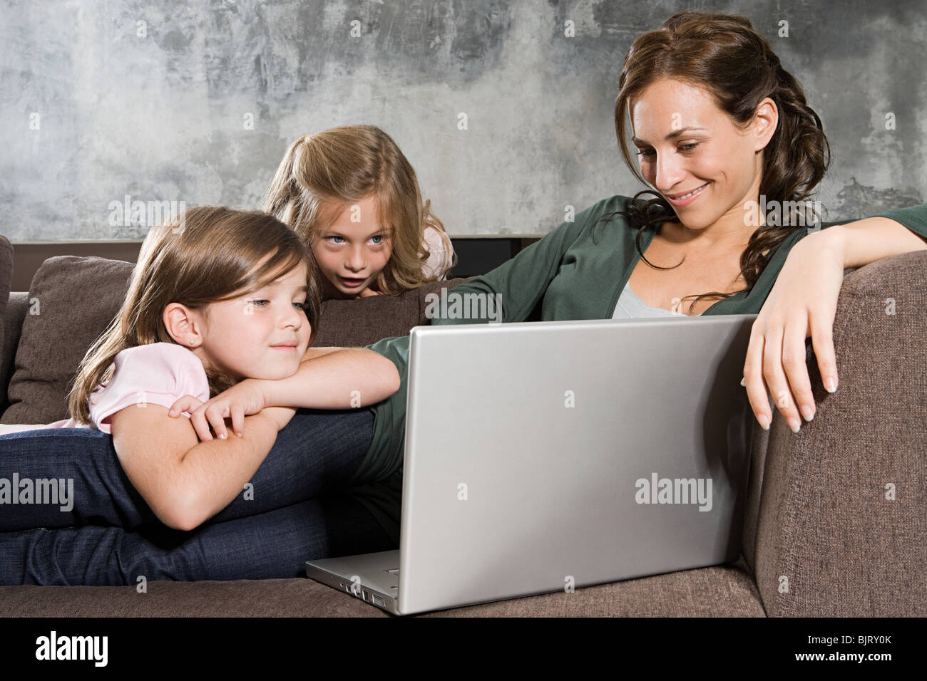 Mother and daughters looking at a laptop Stock Photo