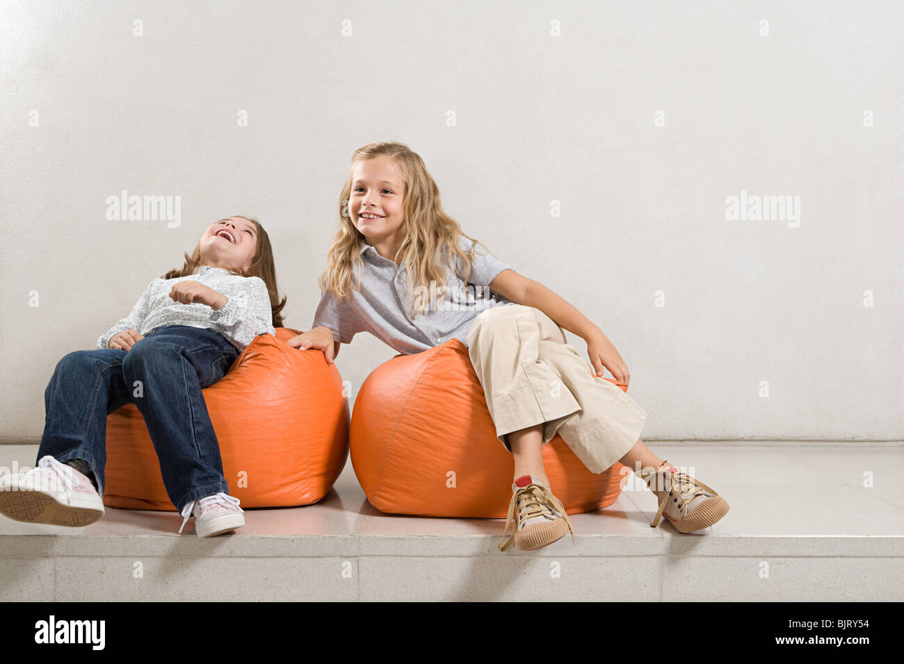 Sisters sat on bean bags Stock Photo - Alamy