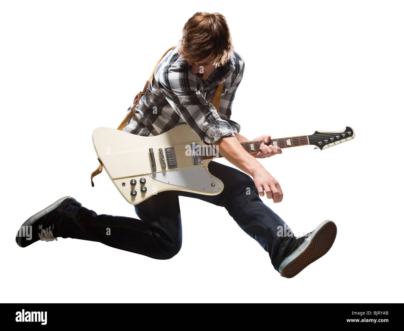Young man playing electric guitar and jumping Stock Photo - Alamy