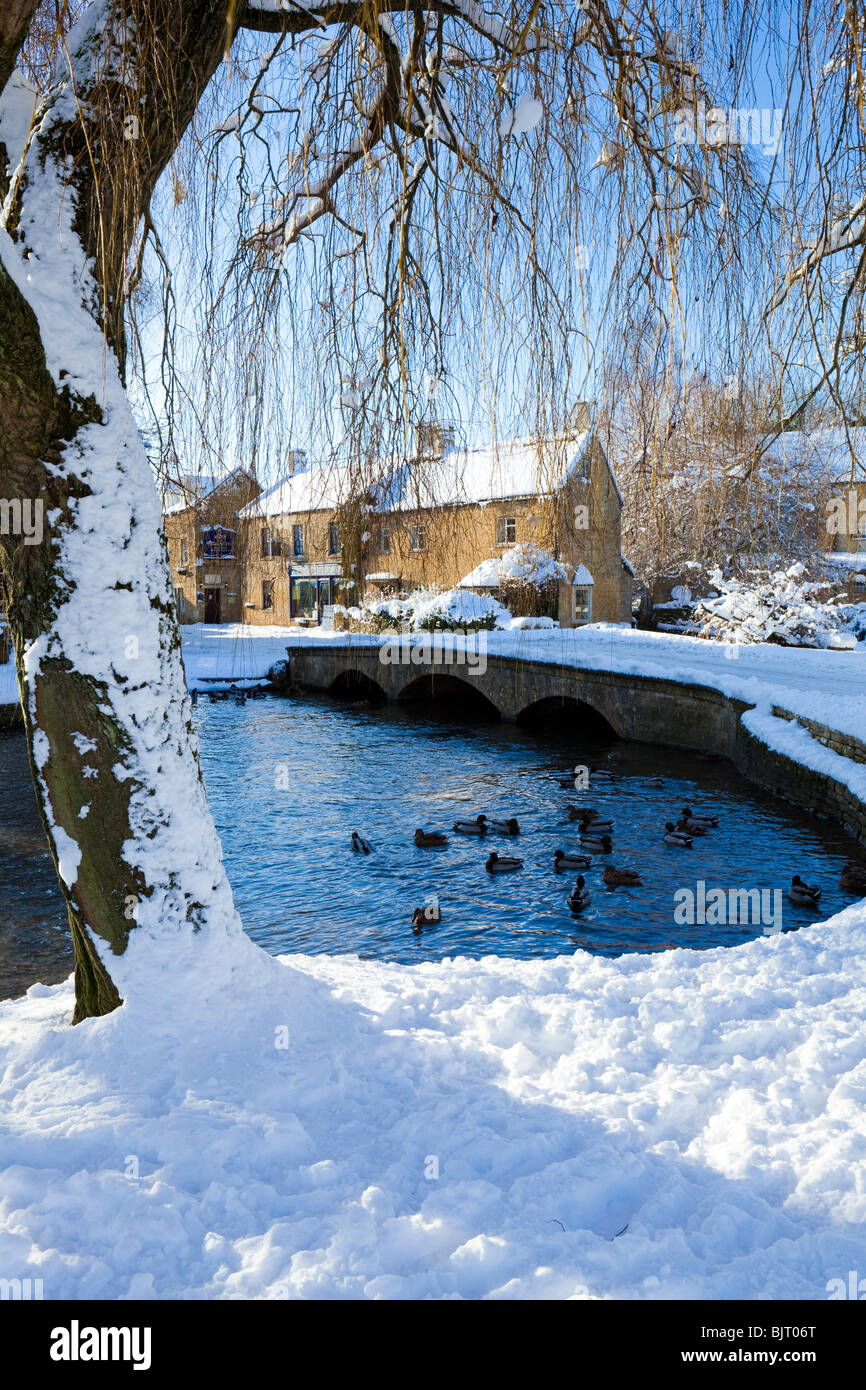 Winter snow on one of the bridges over the River Windrush in the Cotswold village of Bourton on the Water, Gloucestershire UK Stock Photo