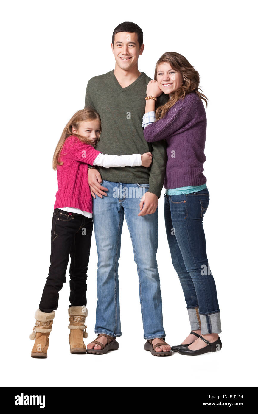 Portrait of young man with teenage girl (16-17) and primary age girl (8-9), studio shot Stock Photo