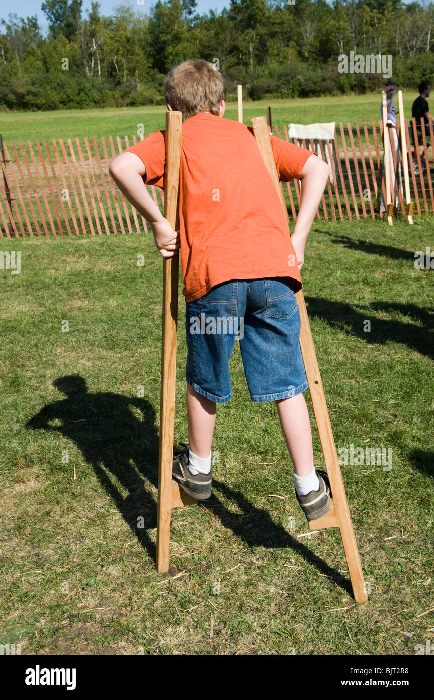 Child walking on wooden stilts learning how to balance on an object Stock Photo Alamy