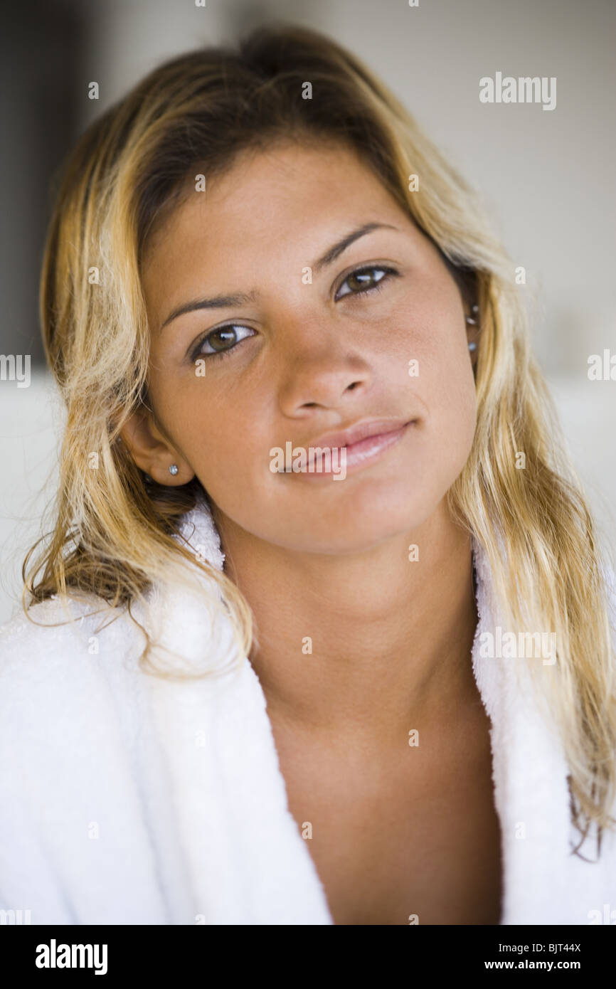 Woman in housecoat sitting on a bed Stock Photo