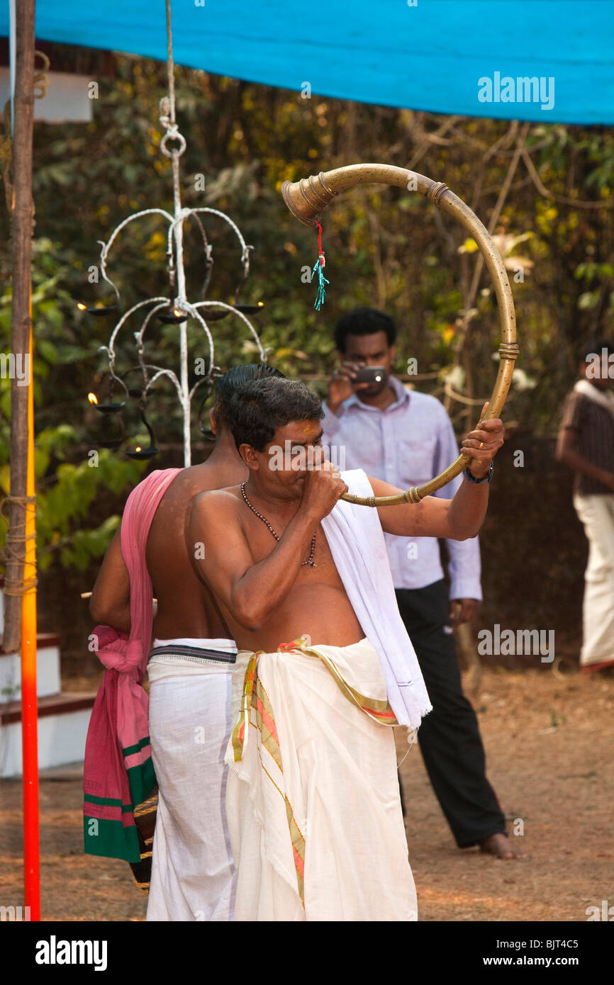 India, Kerala, Cannanore (Kannur), Theyyam, Naga Kanni ritual, temple musician blowing Kombu Horn Stock Photo