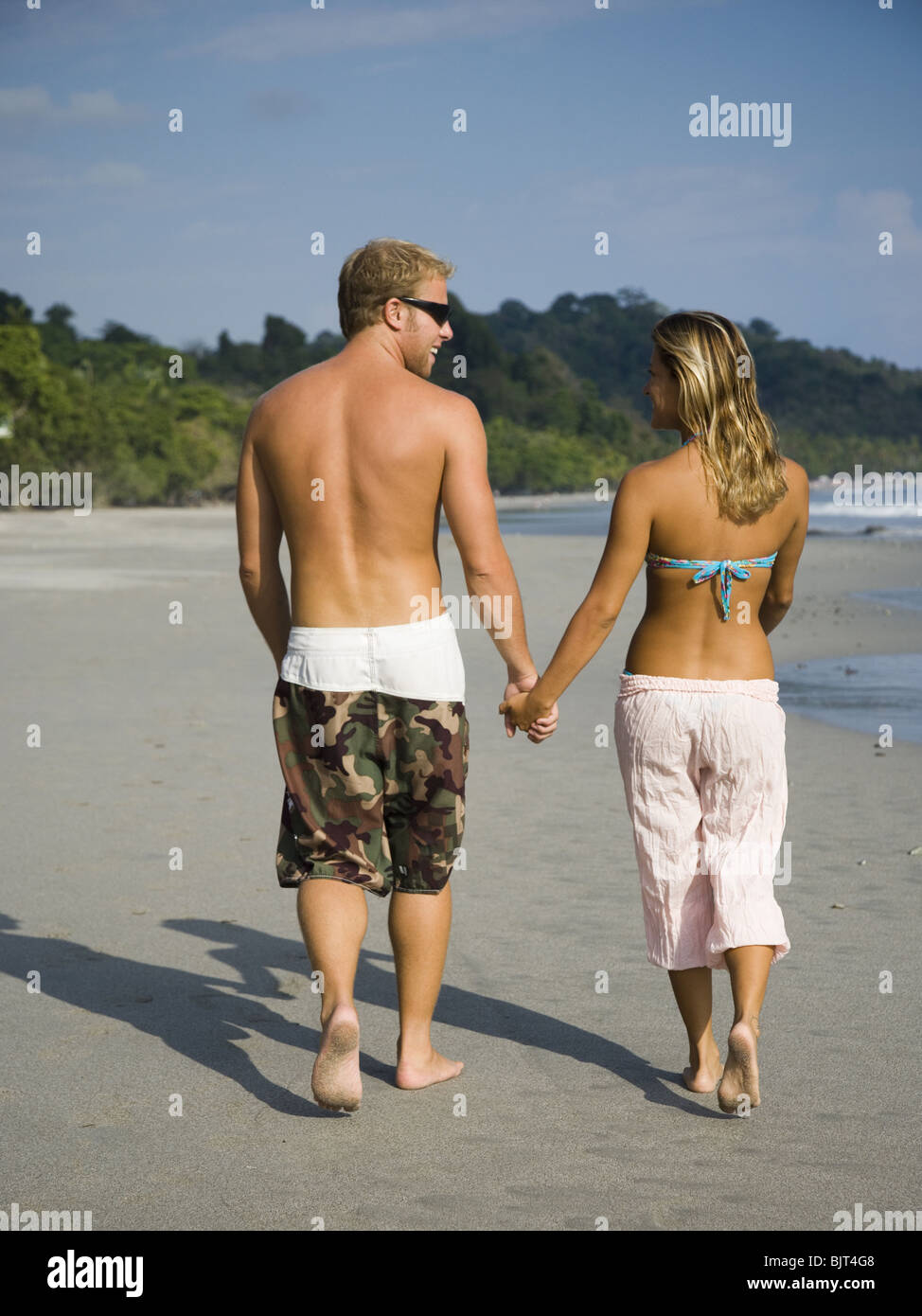 Romantic couple strolling on the beach Stock Photo